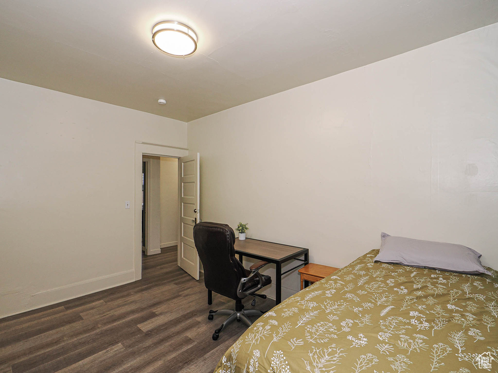 Bedroom featuring dark wood-style floors and baseboards