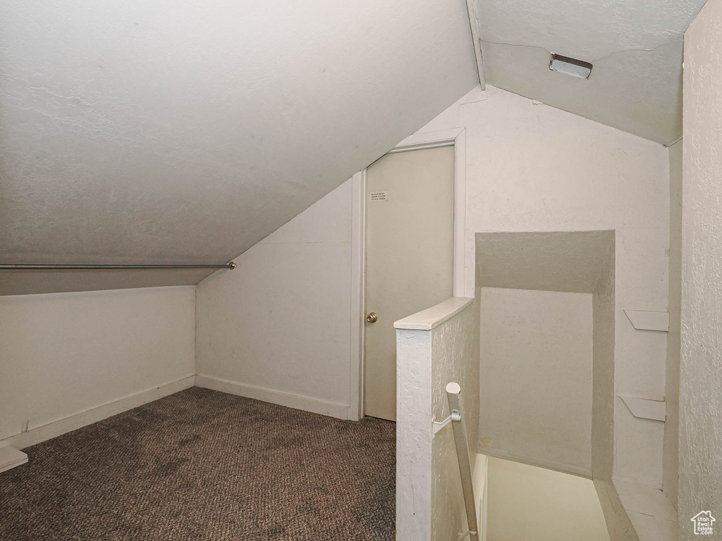 Bonus room with lofted ceiling, carpet flooring, and baseboards