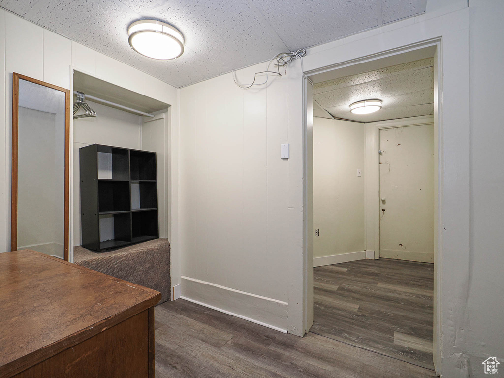 Corridor featuring dark wood-style flooring and baseboards