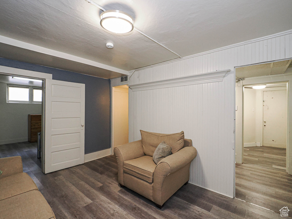 Living area featuring dark wood-style flooring and baseboards
