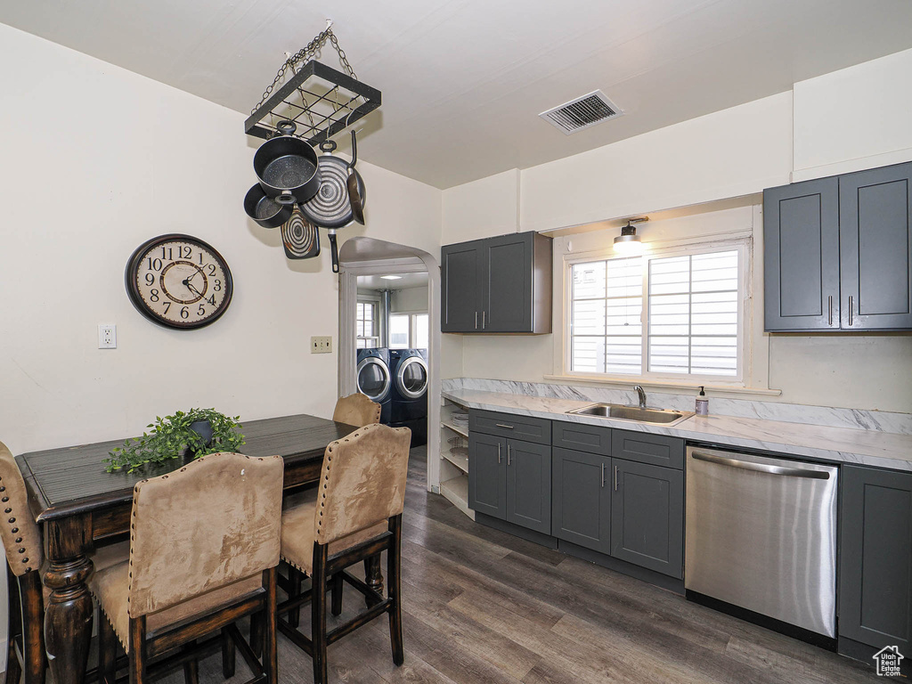 Kitchen featuring dishwasher, washing machine and dryer, a sink, light countertops, and gray cabinets