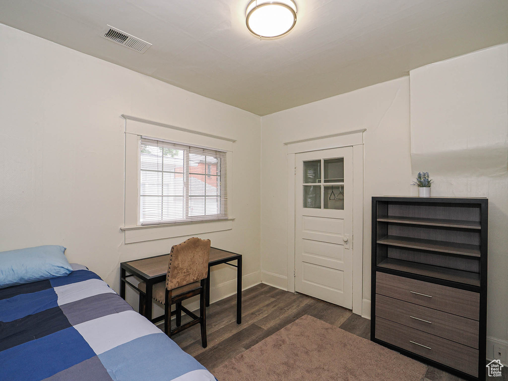 Bedroom with dark wood-type flooring and baseboards