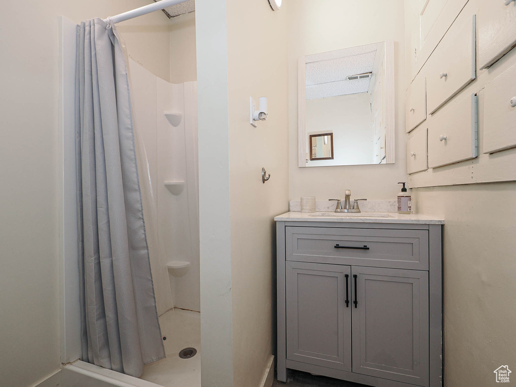 Full bath with a shower stall, baseboards, and vanity
