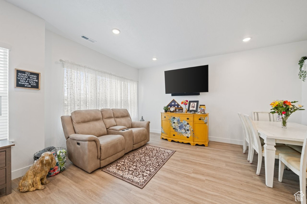 Living area with light wood-type flooring, baseboards, and recessed lighting