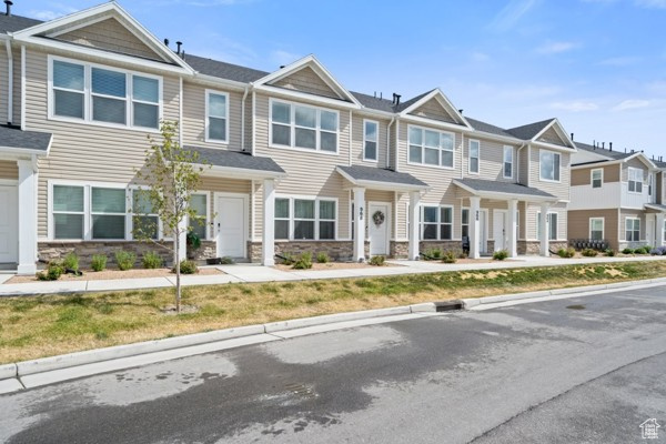 Townhome / multi-family property featuring stone siding and a residential view