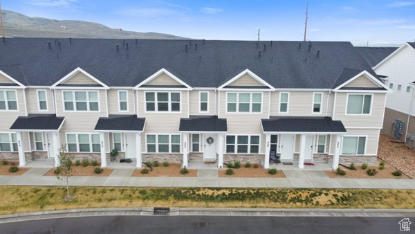 View of property featuring stone siding and central AC unit