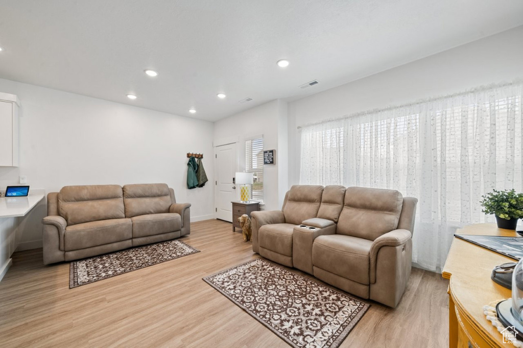 Living room with light wood-style flooring, recessed lighting, and baseboards