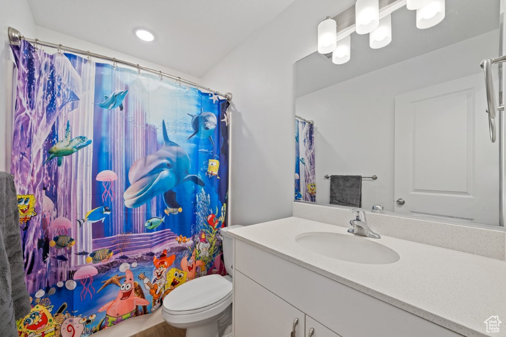 Full bathroom with vanity, toilet, a shower with shower curtain, and recessed lighting