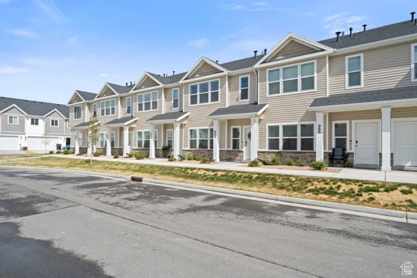 Townhome / multi-family property with a residential view and stone siding