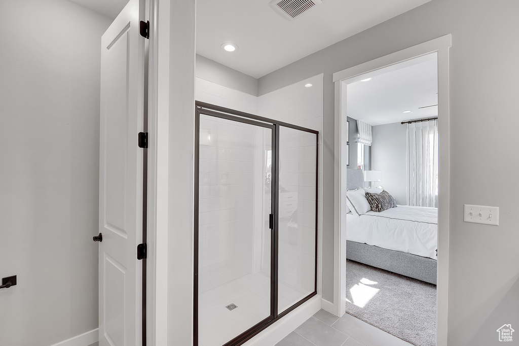 Full bath with a stall shower, ensuite bath, tile patterned flooring, and baseboards