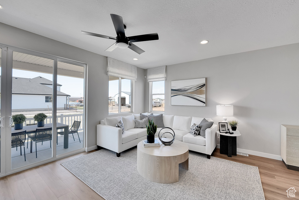 Living room featuring ceiling fan, light wood-style flooring, baseboards, and recessed lighting