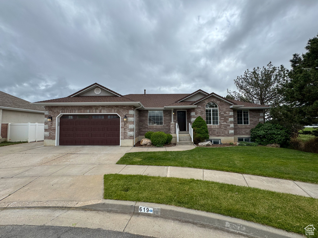 Ranch-style house with driveway, an attached garage, brick siding, and roof with shingles