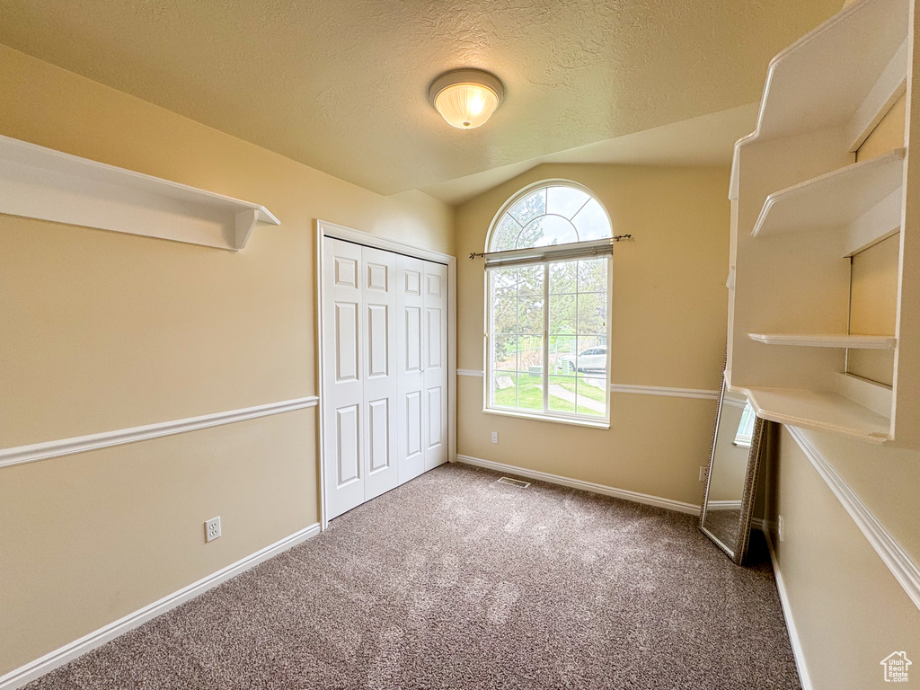 Unfurnished bedroom featuring carpet floors, baseboards, a closet, and a textured ceiling