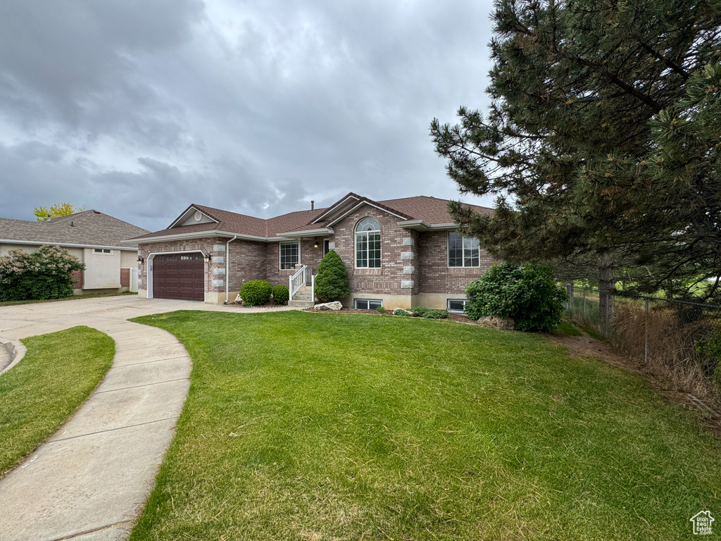 Ranch-style home with driveway, a garage, and brick siding