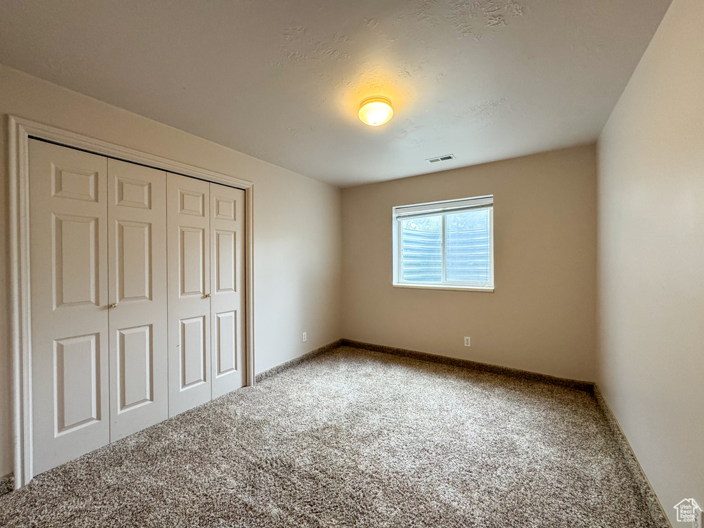 Unfurnished bedroom featuring carpet floors, a closet, and baseboards