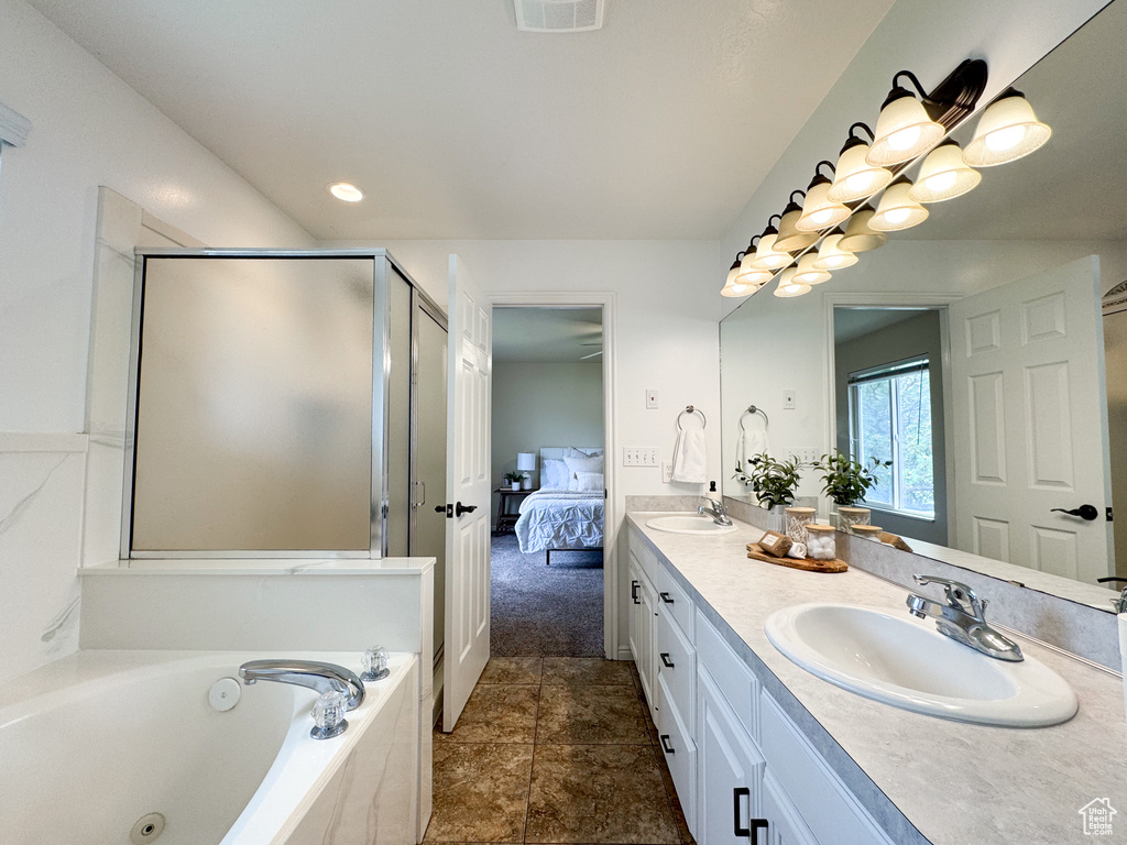 Ensuite bathroom with a bath, a shower stall, double vanity, and tile patterned floors
