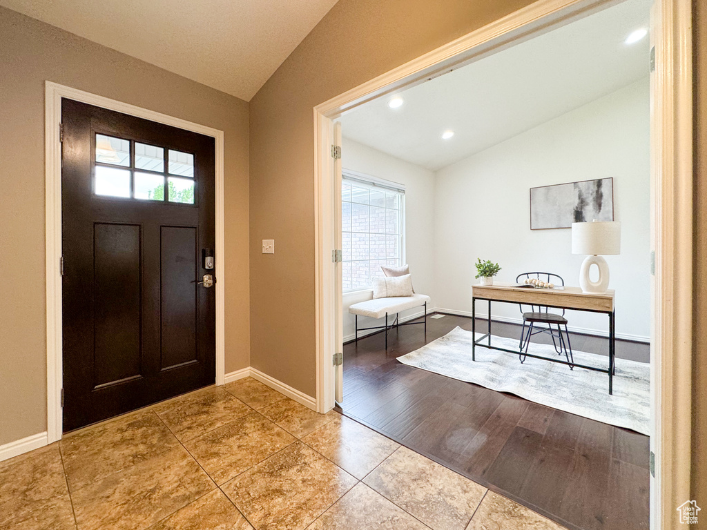Tiled entrance foyer with lofted ceiling, plenty of natural light, baseboards, and recessed lighting