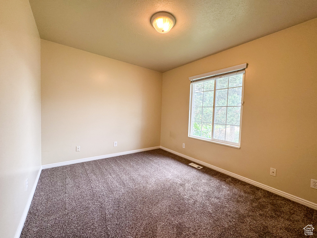 Carpeted spare room with baseboards