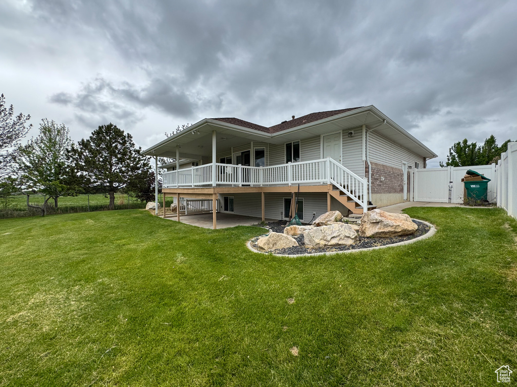 Back of property featuring a gate, a patio area, and a wooden deck