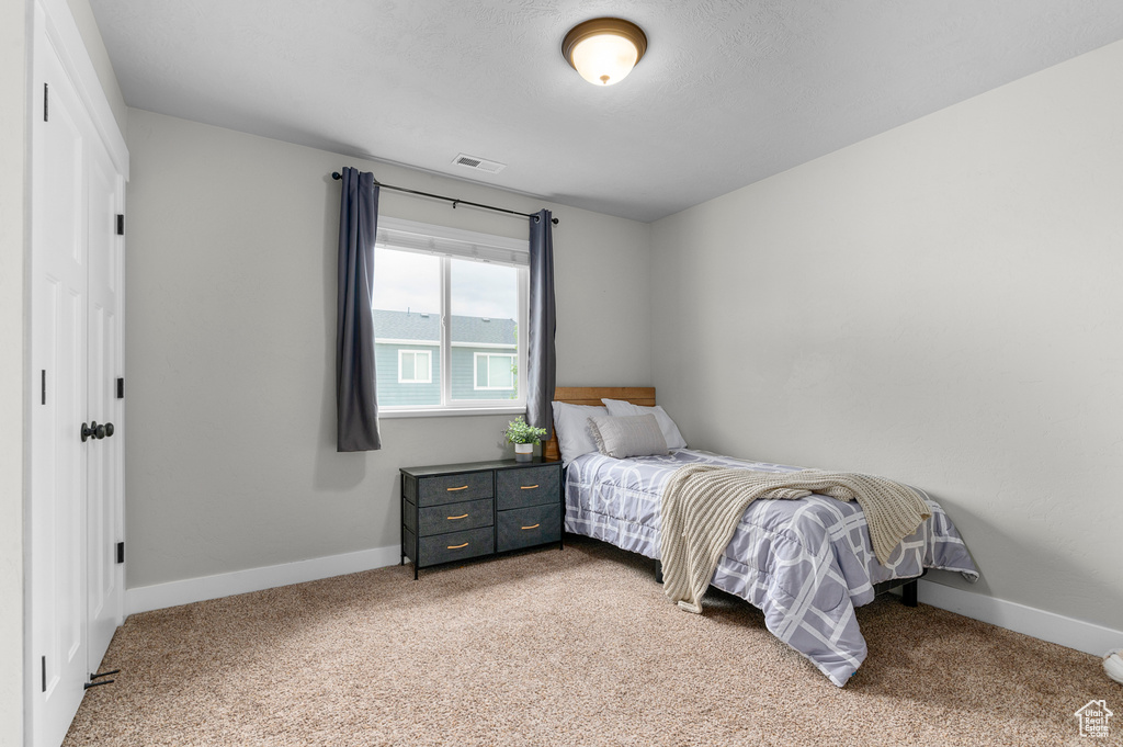 Bedroom with light colored carpet and baseboards