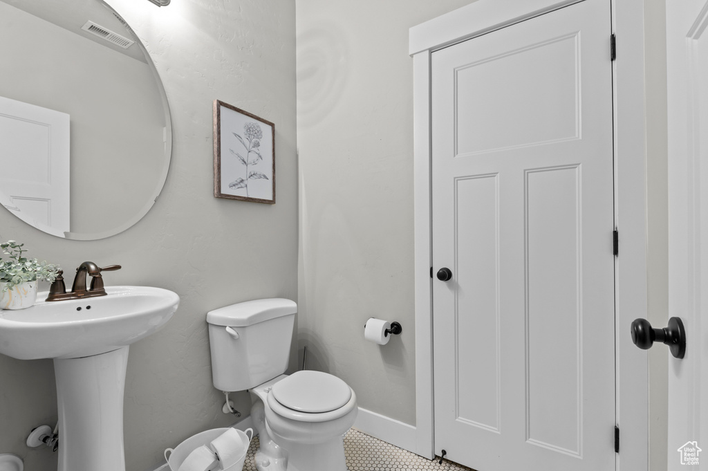 Bathroom with toilet, a sink, and baseboards