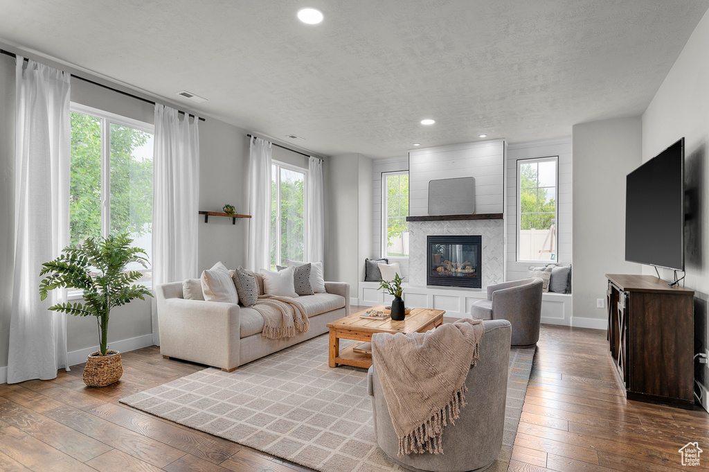 Living area featuring recessed lighting, hardwood / wood-style flooring, a high end fireplace, baseboards, and plenty of natural light