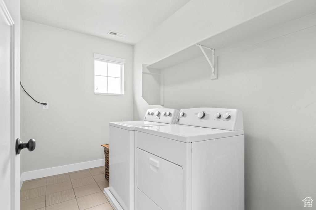 Clothes washing area featuring washer and dryer and baseboards