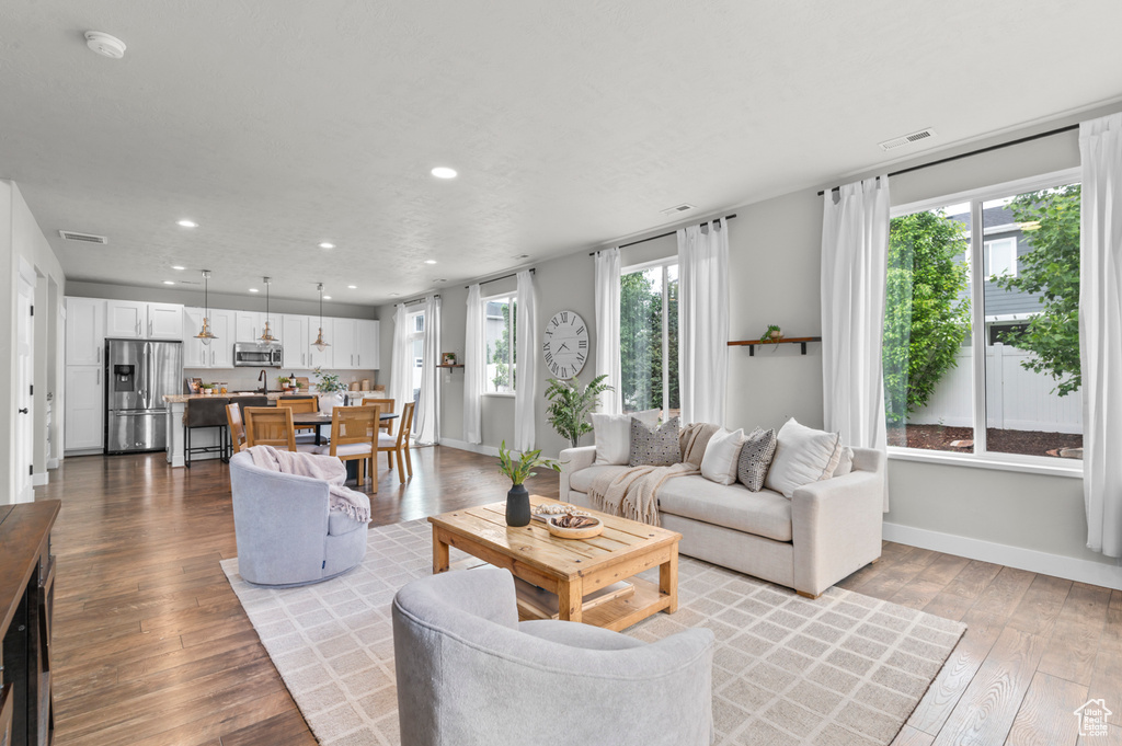 Living room featuring recessed lighting, hardwood / wood-style flooring, and baseboards