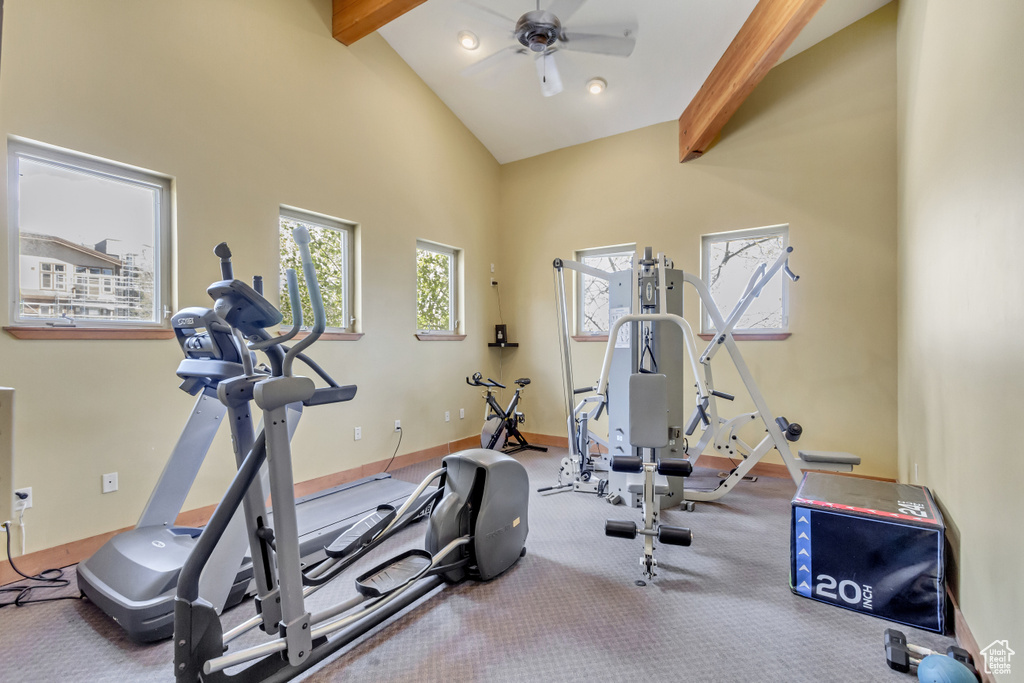 Workout area with ceiling fan, high vaulted ceiling, and baseboards