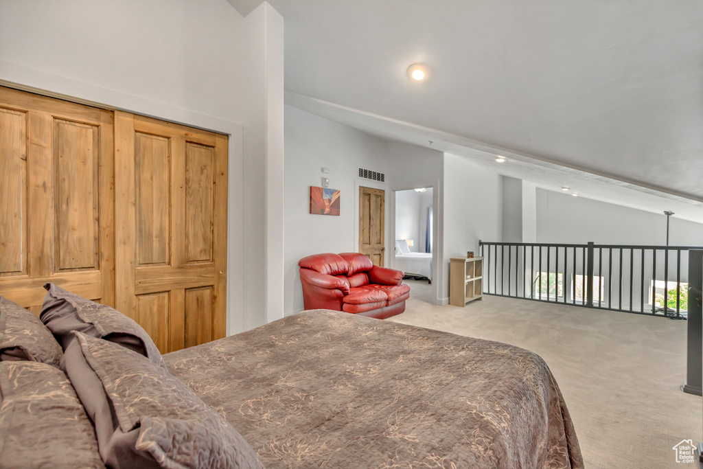 Carpeted bedroom with vaulted ceiling and recessed lighting