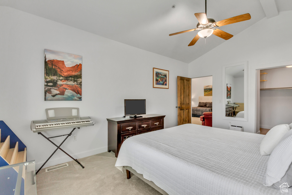 Bedroom featuring light carpet, a ceiling fan, and a walk in closet