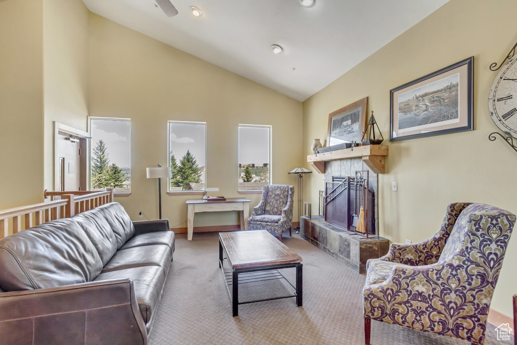 Living room featuring a tiled fireplace, carpet, high vaulted ceiling, and recessed lighting