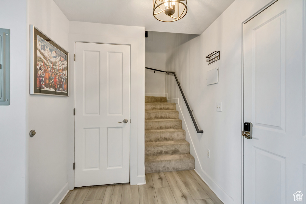 Stairs with wood finished floors and baseboards