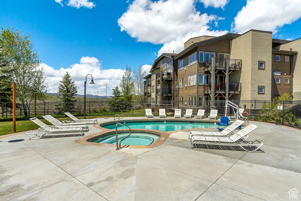 Community pool featuring a community hot tub and a patio