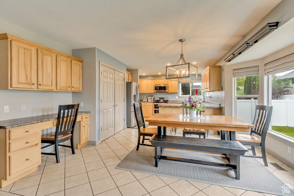 Dining space featuring a chandelier, light tile patterned flooring, and recessed lighting