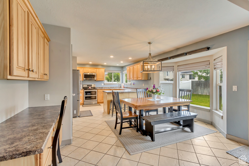 Dining space with recessed lighting, light tile patterned flooring, and baseboards