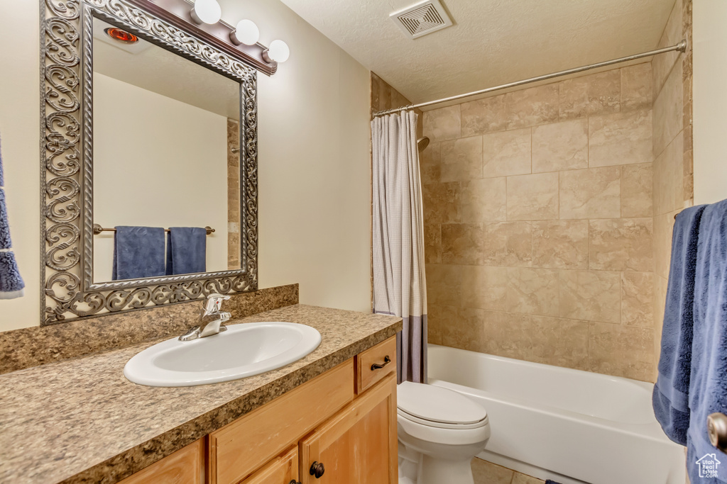 Full bath featuring shower / bath combination with curtain, toilet, vanity, and tile patterned floors