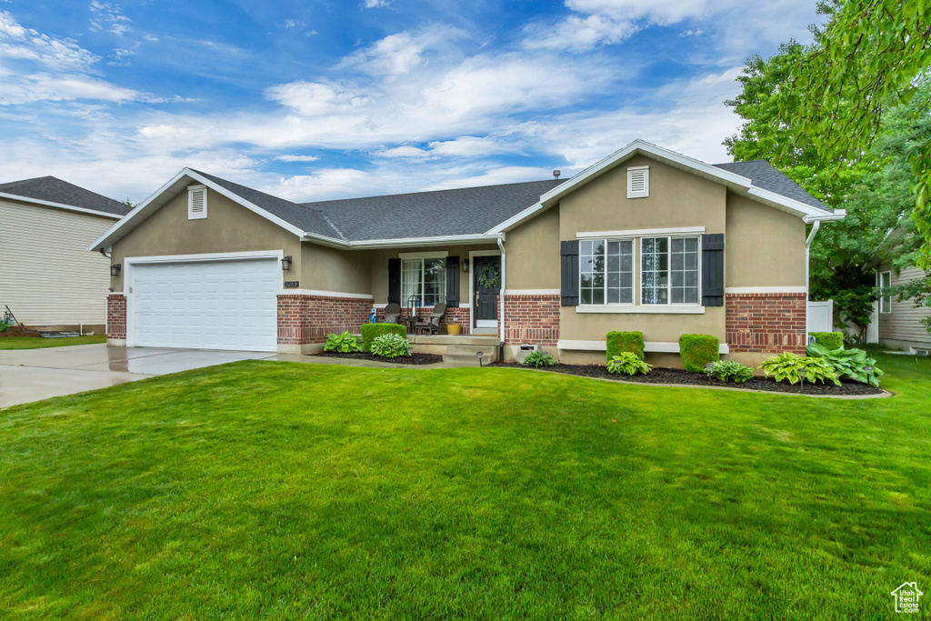 View of front of home featuring brick siding, a porch, an attached garage, and driveway