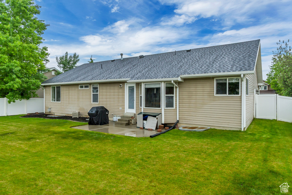 Rear view of house featuring entry steps, a patio area, and roof with shingles
