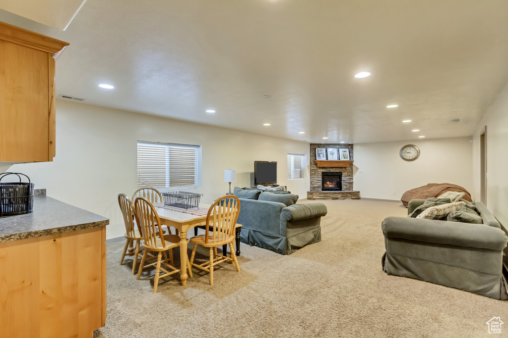 Carpeted living room with a stone fireplace and recessed lighting