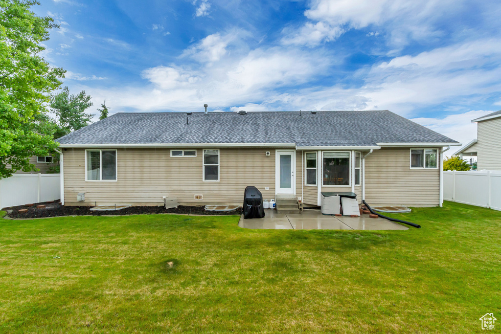 Rear view of house featuring entry steps, a patio area, and roof with shingles