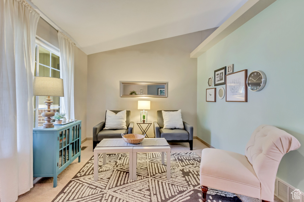 Sitting room with light carpet, baseboards, and vaulted ceiling