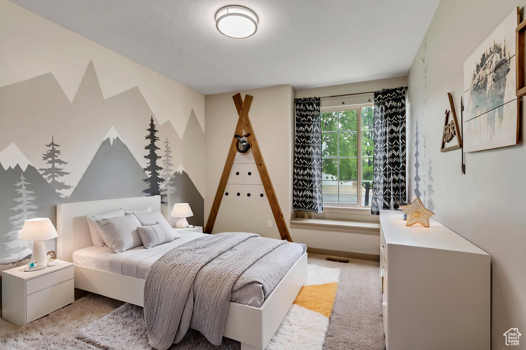 Bedroom featuring light carpet