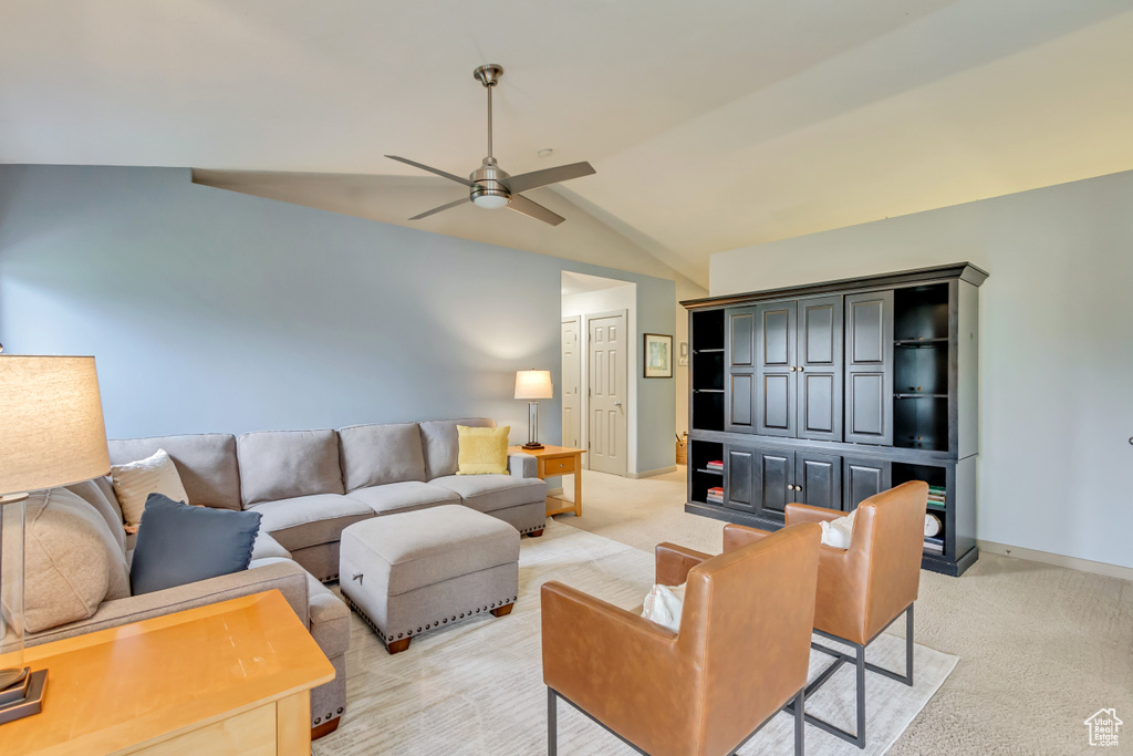 Living room featuring light carpet, vaulted ceiling, ceiling fan, and baseboards
