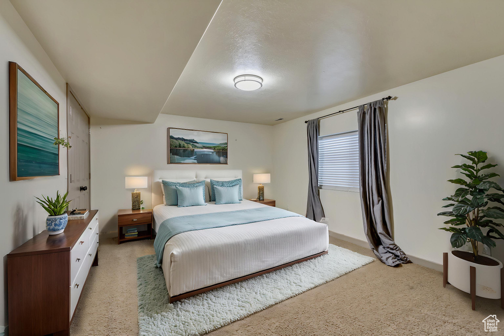Bedroom featuring light carpet and baseboards