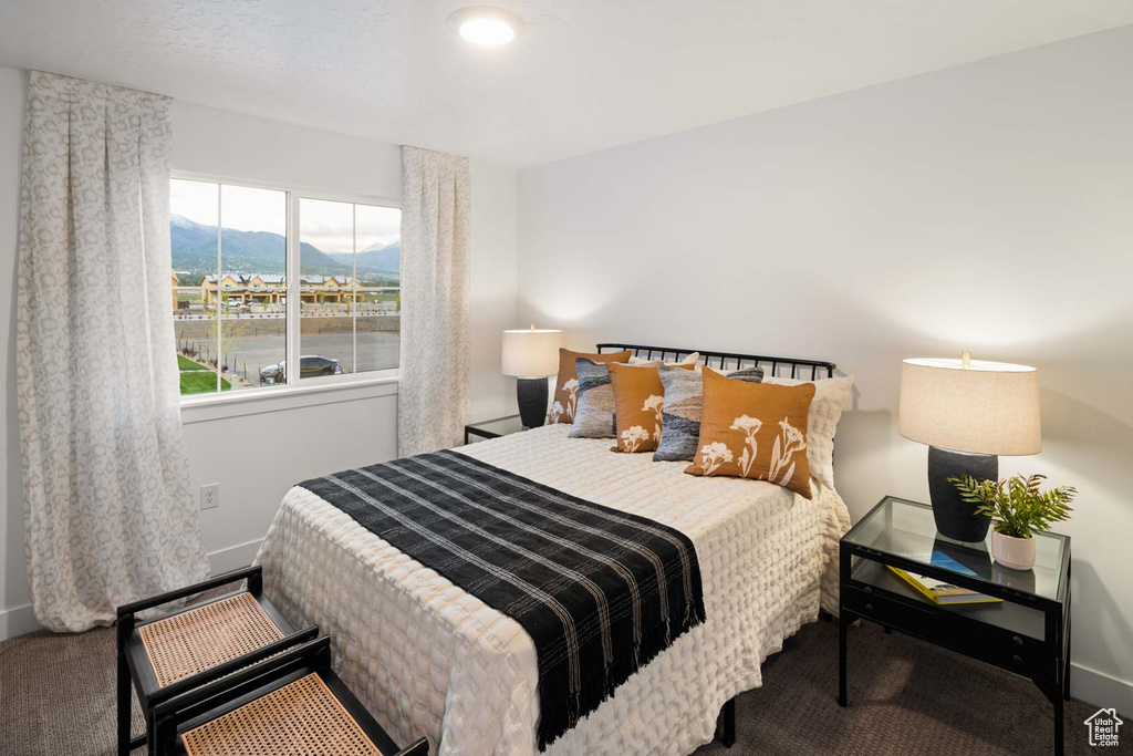 Bedroom with carpet flooring, baseboards, and a mountain view