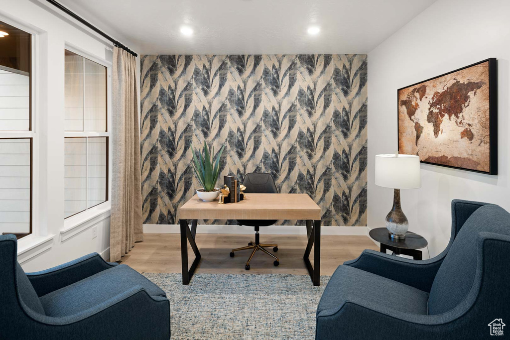Home office with light wood-type flooring, wallpapered walls, recessed lighting, baseboards, and an accent wall