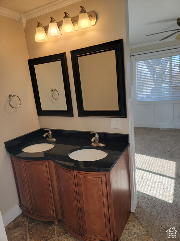 Bathroom with ornamental molding, ceiling fan, and double vanity