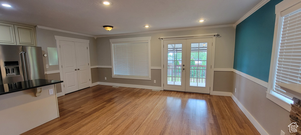 Entryway featuring french doors, light wood-type flooring, baseboards, ornamental molding, and recessed lighting