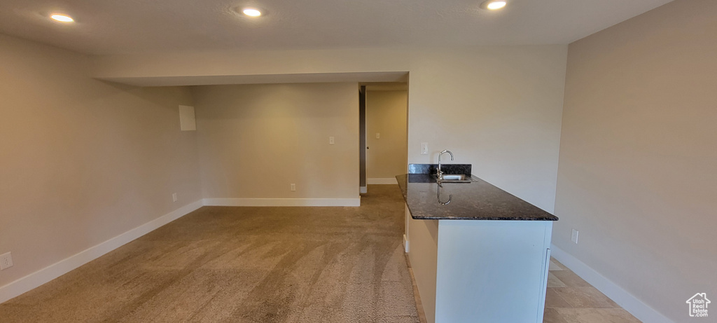 Spare room with recessed lighting, a sink, baseboards, and light colored carpet